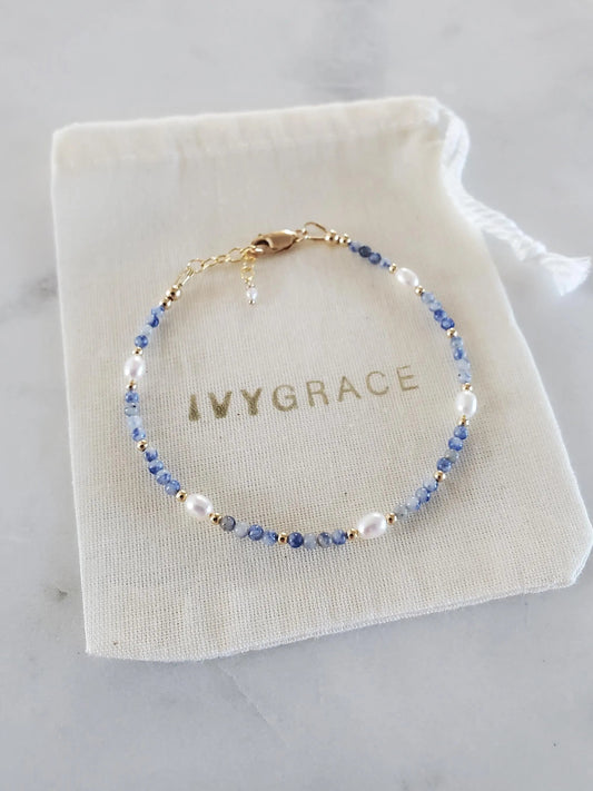 Beaded bracelet on a white drawstring bag with 'IVYGRACE' branding, on a light gray surface.